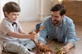 Happy father wearing glasses and little son playing with toys Royalty Free Stock Photo