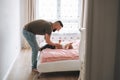 Happy father young man and baby girl little daughter having fun on bed in room at home Royalty Free Stock Photo