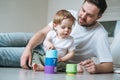 Happy father young man and baby girl little daughter having fun playing with toy in children room at home Royalty Free Stock Photo