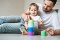 Happy father young man and baby girl little daughter having fun playing with toy in children room at home, selective focus Royalty Free Stock Photo