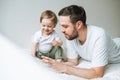 Happy father young man and baby girl little daughter having fun reading a book in children room at home Royalty Free Stock Photo