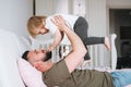 Happy father young man and baby girl little daughter having fun on bed in at home Royalty Free Stock Photo