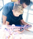 Happy father with young son using tablet PC in sunny room.Dad and little boy playing computer resting indoor together.Vertical, bl Royalty Free Stock Photo