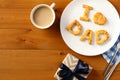 Happy Fathers Day concept. Breakfast with I Love Dad pastry, cutlery, coffee cup, gift box on wooden table. Flat lay, top view Royalty Free Stock Photo