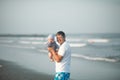 Happy Fathers day. Father and baby play on the beach. Dad and him Child together enjoying sunset. Loving single father hugs cute Royalty Free Stock Photo