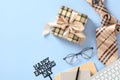 Happy Fathers Day flat lay composition with vintage gift box, keyboard, glasses, necktie on blue table top view