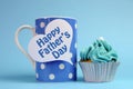 Happy Fathers Day message on blue theme polka dot coffee mug with cupcake. Royalty Free Stock Photo
