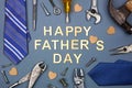 Happy Fathers Day message with frame of ties and and tools on a grey blue paper background Royalty Free Stock Photo