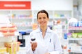 Happy female apothecary with drug at pharmacy Royalty Free Stock Photo