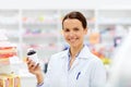 Happy female apothecary with drug at pharmacy Royalty Free Stock Photo