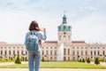 Female asian tourist in the baroque garden in front of the ancient architecture of royal Charlottenburg palace. Sightseeing