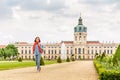 female asian tourist in the baroque garden in front of the ancient architecture of royal Charlottenburg palace. Sightseeing