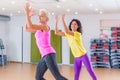 Happy female athletes doing aerobics exercises or Zumba dance workout to lose weight during group classes in fitness Royalty Free Stock Photo