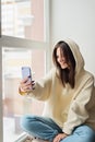 Happy female blogger taking selfie portrait on smartphone camera for social media posting, cheerful teenage girl talking on video Royalty Free Stock Photo