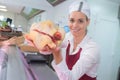 Happy female butcher showing meat