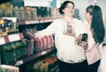 Happy female buyers selecting brown buckwheat at grocery Royalty Free Stock Photo