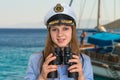 Happy female captain holding binoculars