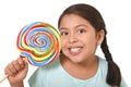 Happy female child holding big lollipop candy in cheerful face expression in kid love for sweet concept
