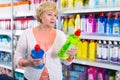 Happy female choosing household chemical goods