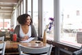 Happy female college student sitting at restaurant with note pad Royalty Free Stock Photo