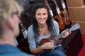 Happy female customer trying to play guitar in store