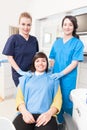 Happy female dentist with assistant and patient at dental office