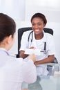 Happy female dentist giving prescription to patient