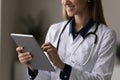 Happy female doctor attending physician making electronic prescription on touchpad