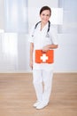 Happy female doctor holding first aid box Royalty Free Stock Photo