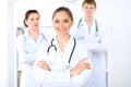 Happy female doctor keeping medical clipboard while medical staff are at the background Royalty Free Stock Photo