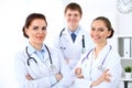 Happy female doctor keeping medical clipboard while medical staff are at the background Royalty Free Stock Photo