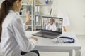 Happy female doctor with laptop computer having video conference at clinic. Royalty Free Stock Photo