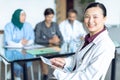 Happy female doctor looking at camera while using digital tablet in the hospital Royalty Free Stock Photo