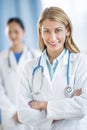 Happy Female Doctor Standing Arms Crossed At Clinic Royalty Free Stock Photo