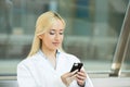 Happy female doctor texting on smart phone Royalty Free Stock Photo