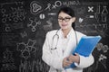 Happy female doctor with written blackboard