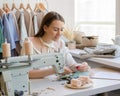 Happy female dressmaker or seamstress using cell phone at her workplace in atelier Royalty Free Stock Photo