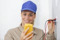 Happy female electrician testing wall socket Royalty Free Stock Photo