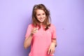 Happy female with feathers in messy hair after pillow fight at pyjamas party