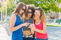 Happy female friends with smartphone outdoors