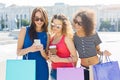 Happy female friends with smartphone outdoors