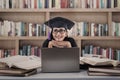 Happy female graduate thinking at library Royalty Free Stock Photo