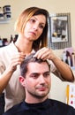 Happy female hairstylist setting client's hair Royalty Free Stock Photo