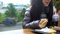 Happy female holding sandwich having dinner cafe, homeless person lying outdoor