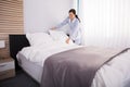 Housekeeper Arranging Pillow On Bed Royalty Free Stock Photo