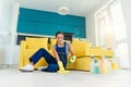 Happy female housekeeper mopping floor with detergents and rag in apartment. Cleaning services concept. Royalty Free Stock Photo