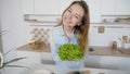 Happy female housewife takes bunch of salad leaves in hands and Royalty Free Stock Photo