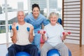 Happy female instructor with arms around senior couple Royalty Free Stock Photo