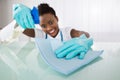 Happy Female Janitor Cleaning Desk With Rag Royalty Free Stock Photo