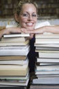 Happy Female Librarian Leaning On Stack Of Books